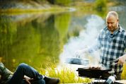 Zwei Männer grillieren am See. Zwei Männer grillieren am See.